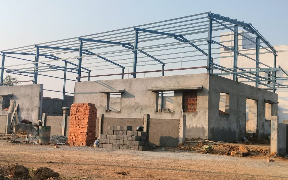 A shed under construction with block walls built up and the steel roof frame above